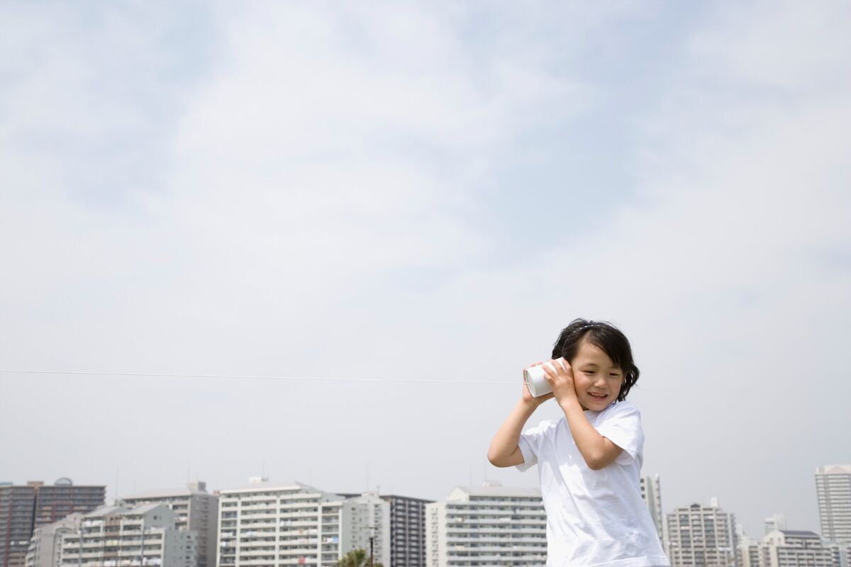 糸電話で耳を澄ます子ども